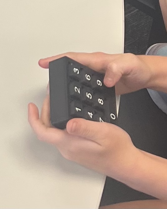 Black 3D printed 10-key practice keypad with white numbers